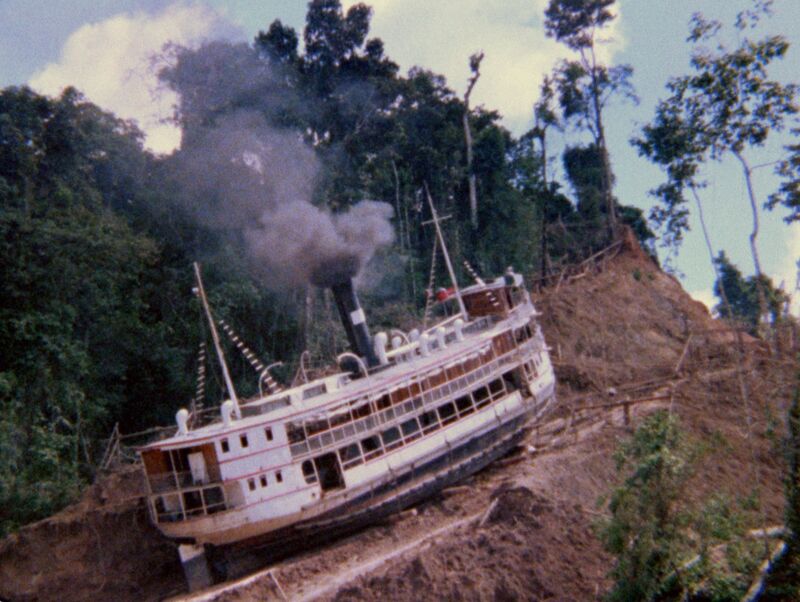A white ship sits on a hill in a jungle.