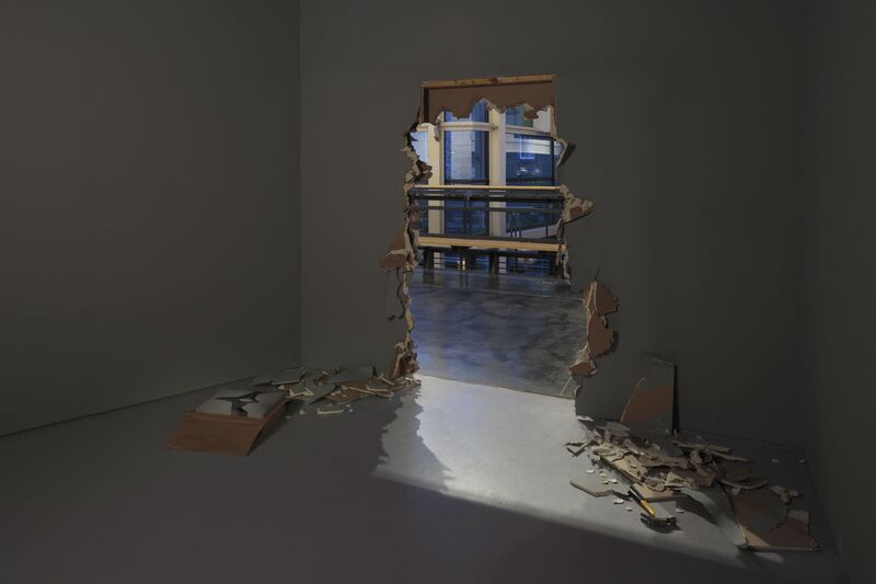 Margaret Salmon's exhibition Hole shows a large, smashed hole in the gallery wall. The foyer of DCA can be seen through the hole.