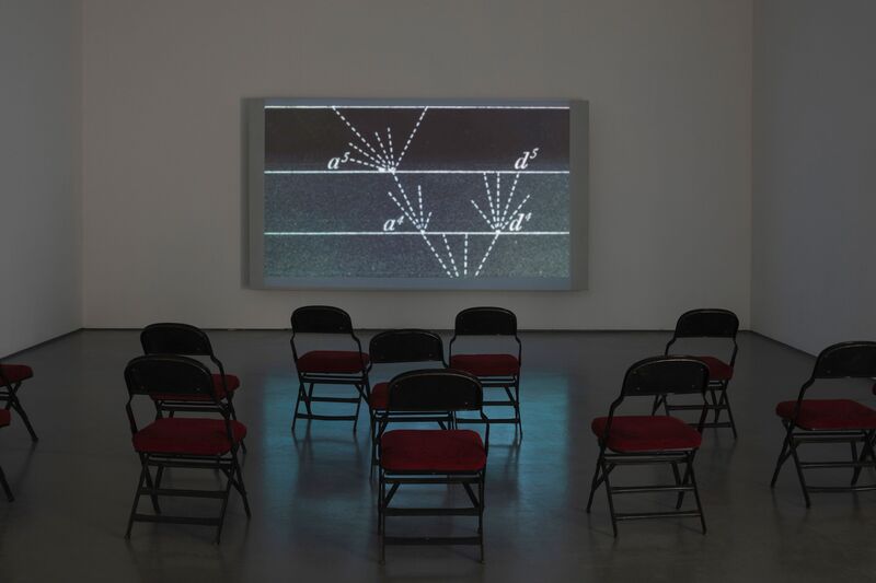 Chairs in the gallery space look at a work from Duncan Marquis's exhibition Copying Errors. White, dashed diagonal lines appear on a black background.