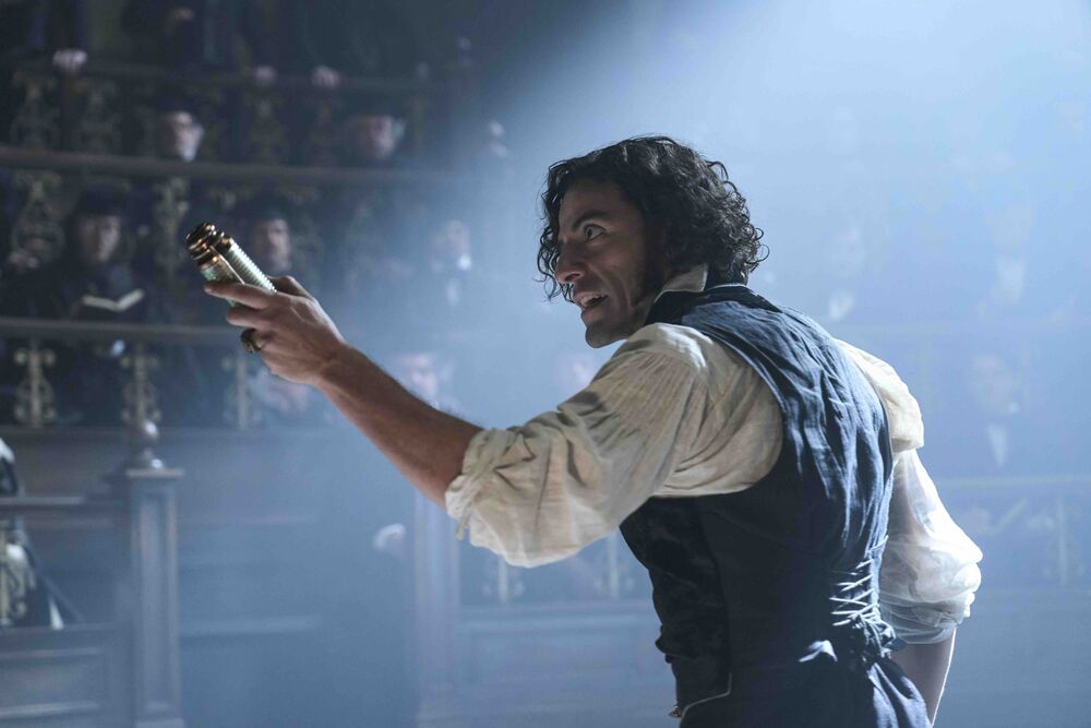 A man holds a vial up to an audience in a Victorian theatre