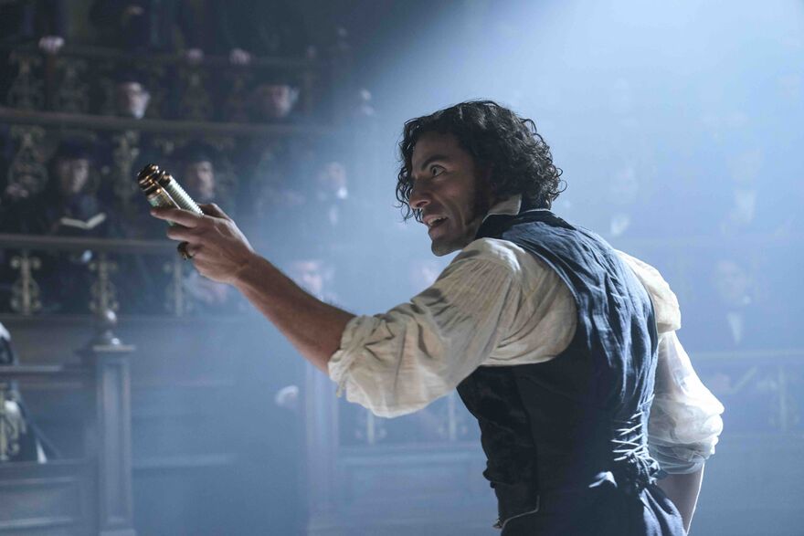 A man holds a vial up to an audience in a Victorian theatre