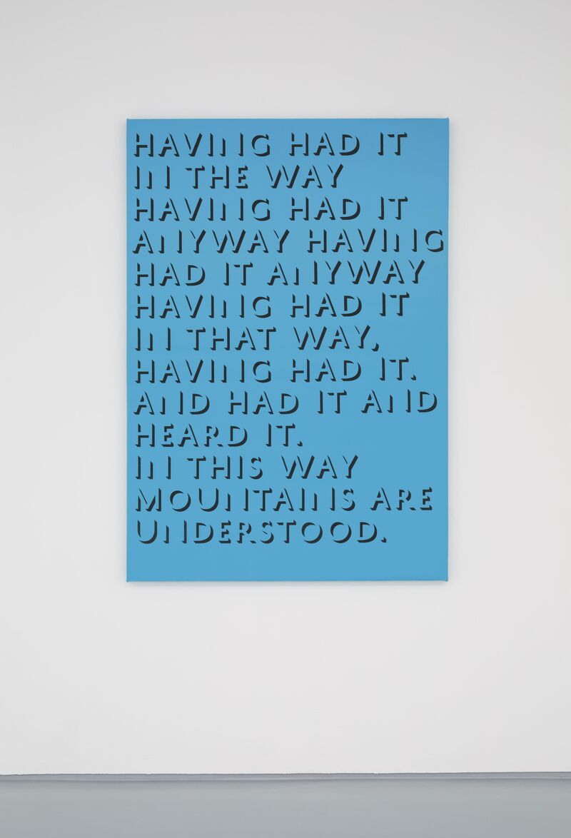 From Eve Fowler's exhibition. A blue canvas on the wall says 'Having had it in the way having had it anyway having had it anyway having had it in that way. having had it and had it and heard it in this way. mountains are understood'.