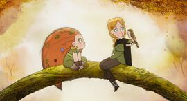 An animation still shows a blonde girl and a ginger child sitting on a tree branch together with a bird.