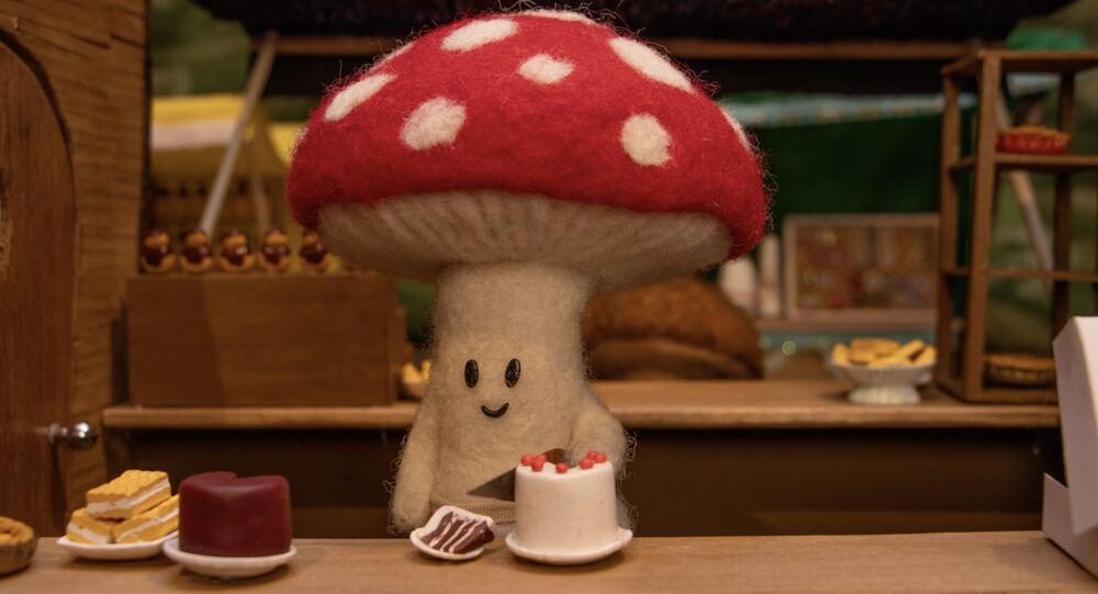 A small felt mushroom cutting a slice of cake 
