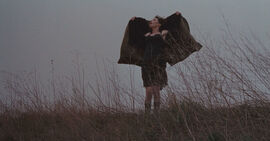 Woman standing outside holding her coat open