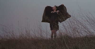 Woman standing outside holding her coat open