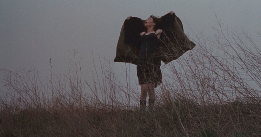 Woman standing outside holding her coat open