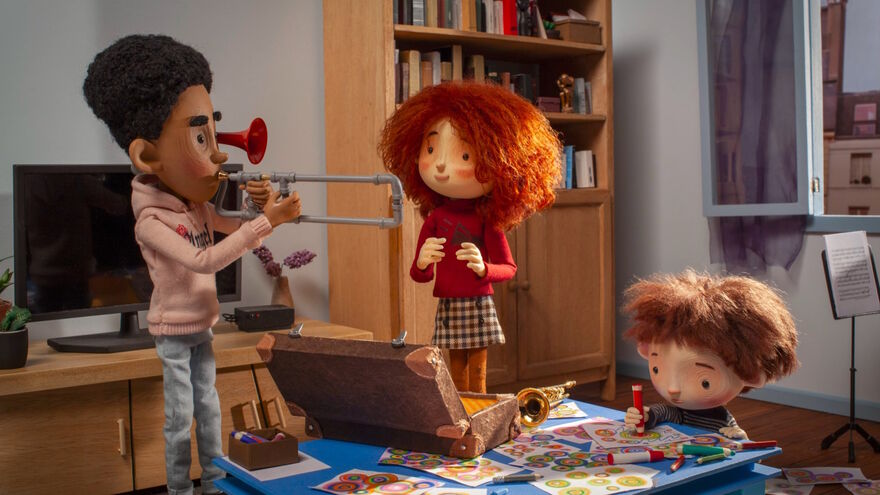 animated children, one playing a trumpet, with another looking on and another sitting drawing a picture 