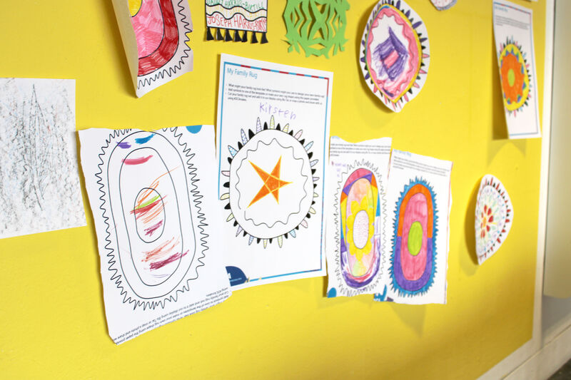 Completed My Family Rug activity sheets on the wall of Create Space