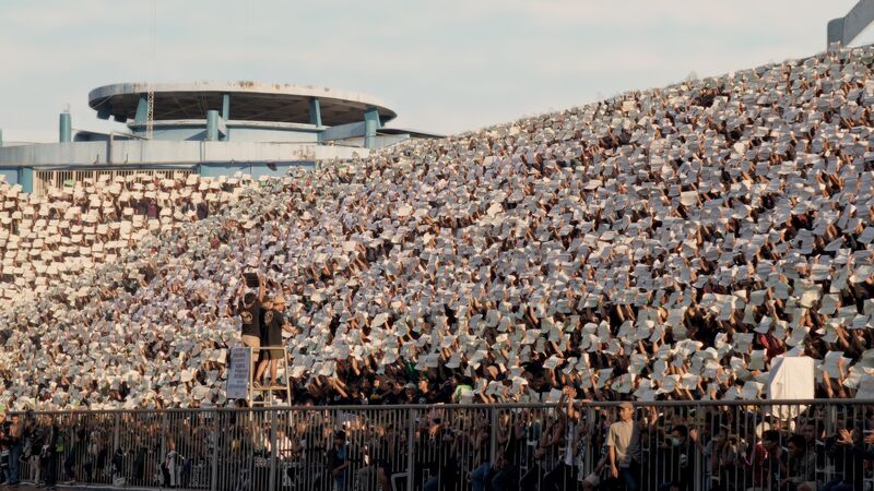 Stadium crowd holding white banners