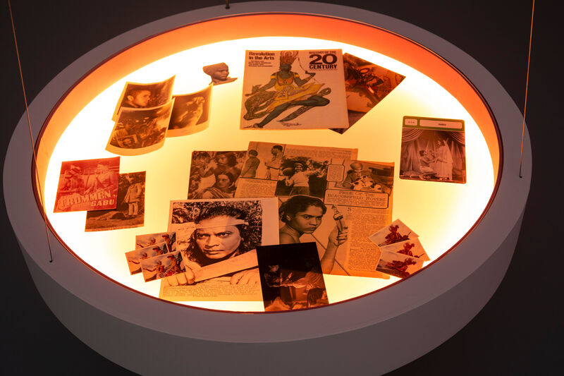 A circular, backlit vitrine seen from above, containing Hollywood memorabilia.