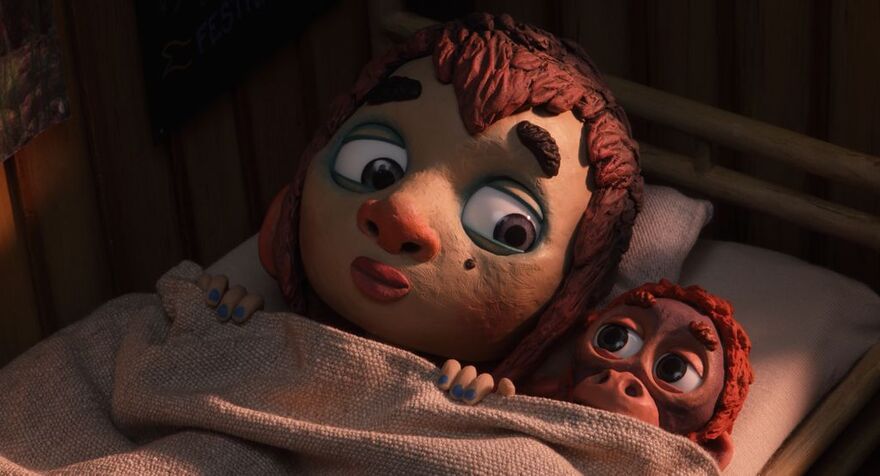 A clay animation boy shares a single bed with a small monkey.
