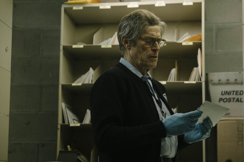 A man in a post office examines a piece of mail