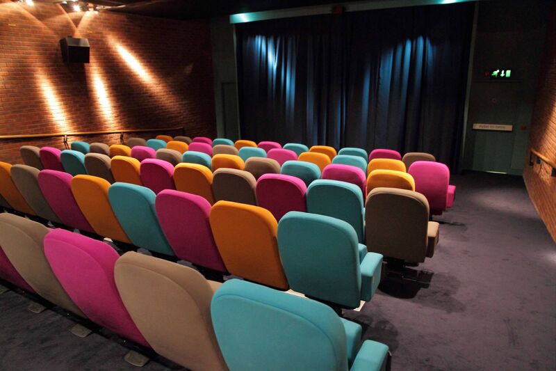 DCA's Cinema 2. The chairs are multi-coloured in pink, orange, beige and teal.