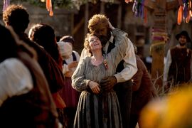 A human woman and a wicker man dancer at a celebration