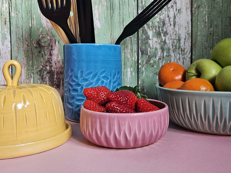 Selection of different ceramic kitchenware, each featuring decorative scored marked and bold colour glaze.
