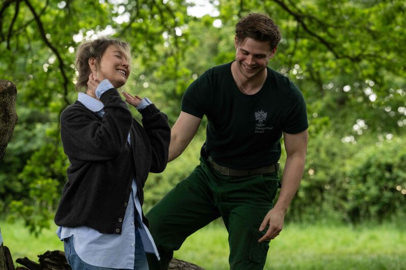 A blonde woman and a greenskeeper dance in a forest.