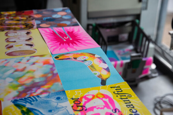 Riso prints on a table beside a Riso Print machine