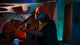 A young Black man rapping on stage