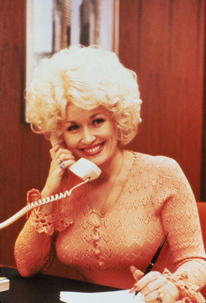 Dolly Parton smiling while talking on the phone