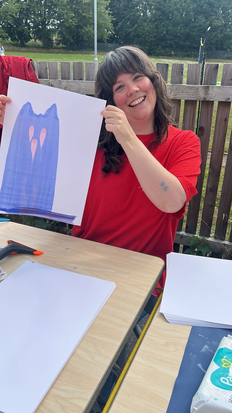 Learning artist showing a squeegee print of a cat