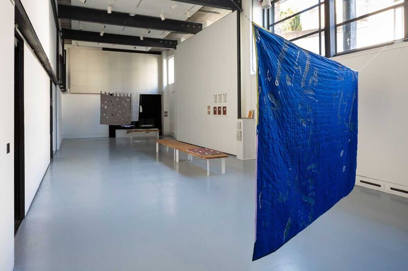 a gallery view with a large blue quilt 