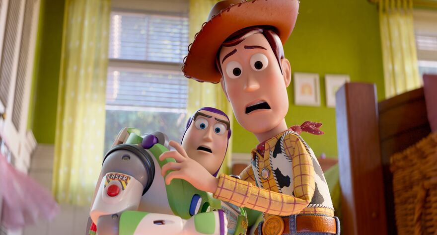 A sheriff toy (right) and an astronaut toy (left) are stood side by side with their arms pulled back in shock, they are in a bedroom. Woody is the sheriff and Buzz Lightyear is the astronaut.