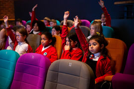 School pupils holding their hands up in DCA Cinema