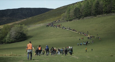 A long line of walkers on a hill