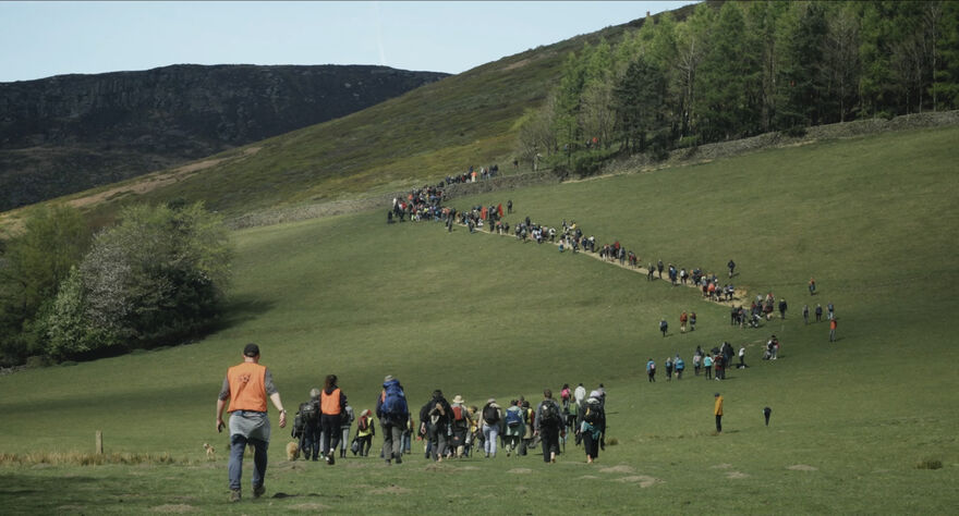 A long line of walkers on a hill