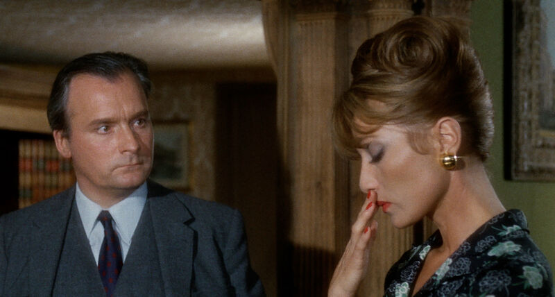 A man stares angrily at a woman, who looks down