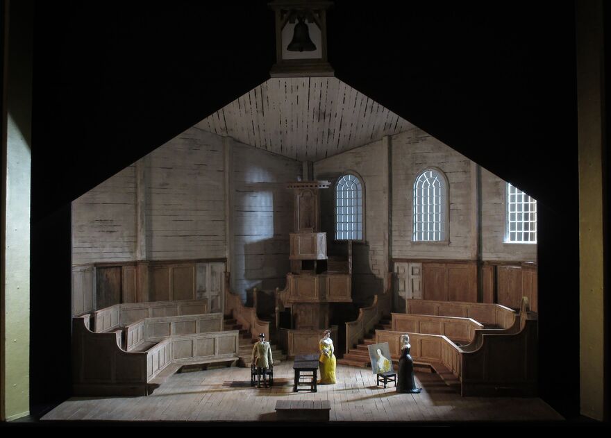 Three singers on stage in a set that looks like a church