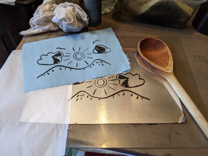 Print of a landscape beside a wooden spoon