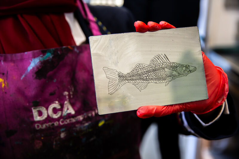 Morgan Academy pupil showing an etching plate with an image of a fish