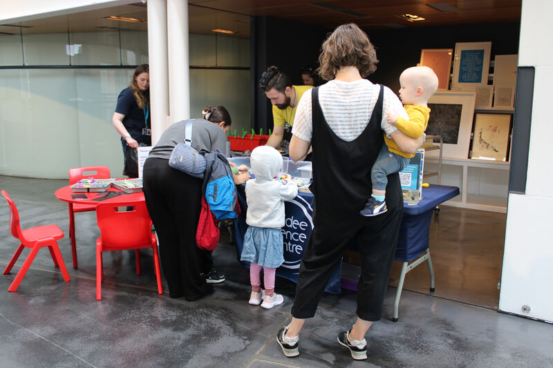 Families trying activities at Dundee Science Centres table at DCA