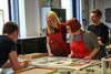 Three people looking at examples of prints created in DCA Print Studio