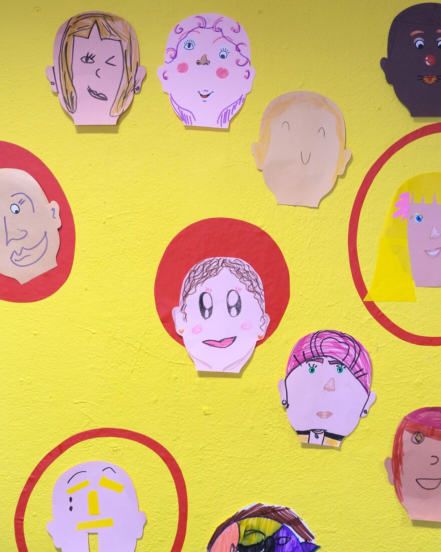 Paper portraits on a yellow wall