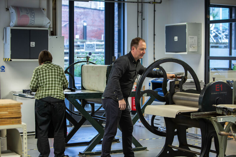 Peolpe working printing presses in DCA Print Studio