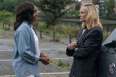 Two woman talk to each other in a tense manner in a carpark.