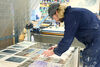 Dominic McKeown laying out screen printed tissues on the drying racks in DCA Print Studio