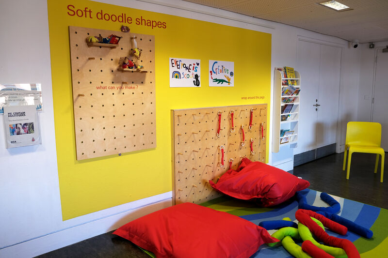 Wall of Create Space with Soft Doodle Shapes activity and big red cushions