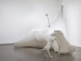 A large white sculpture in the corner with the image of a dog against the 