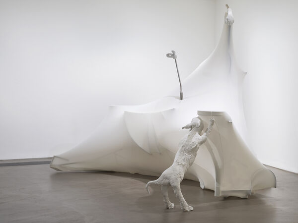 A large white sculpture in the corner with the image of a dog against the 