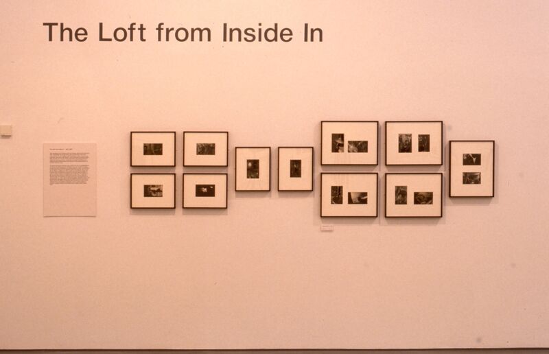 Small black-and-white photos on white backing hang on a. white wall. Text above the frames says 'The Loft from inside in'.