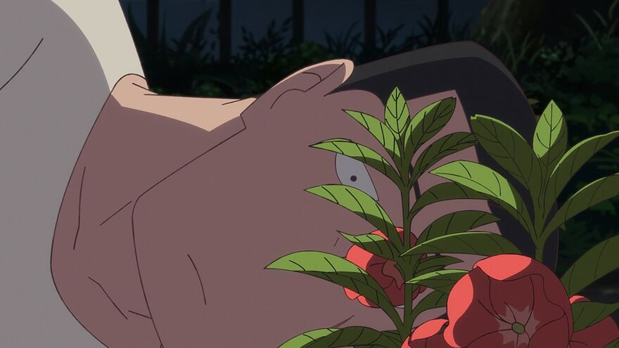An anime still shows a man lying on his side looking at red flowers