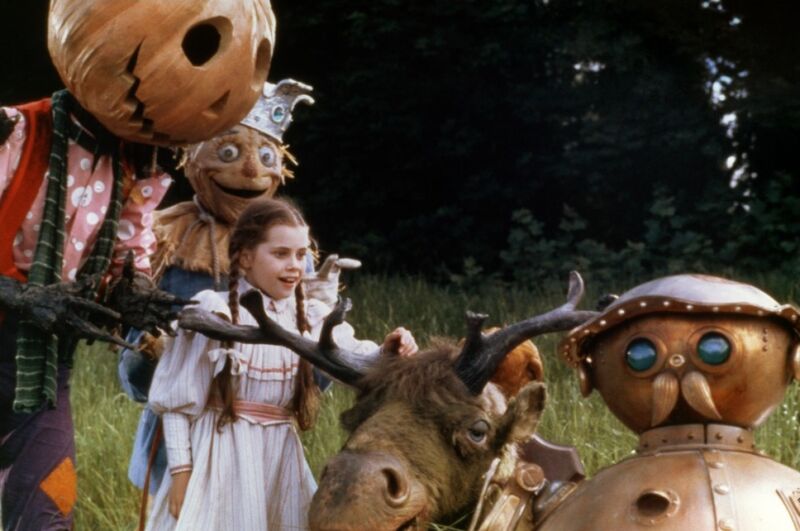 Dorothy stands outside surround by her friends from the Land of Oz