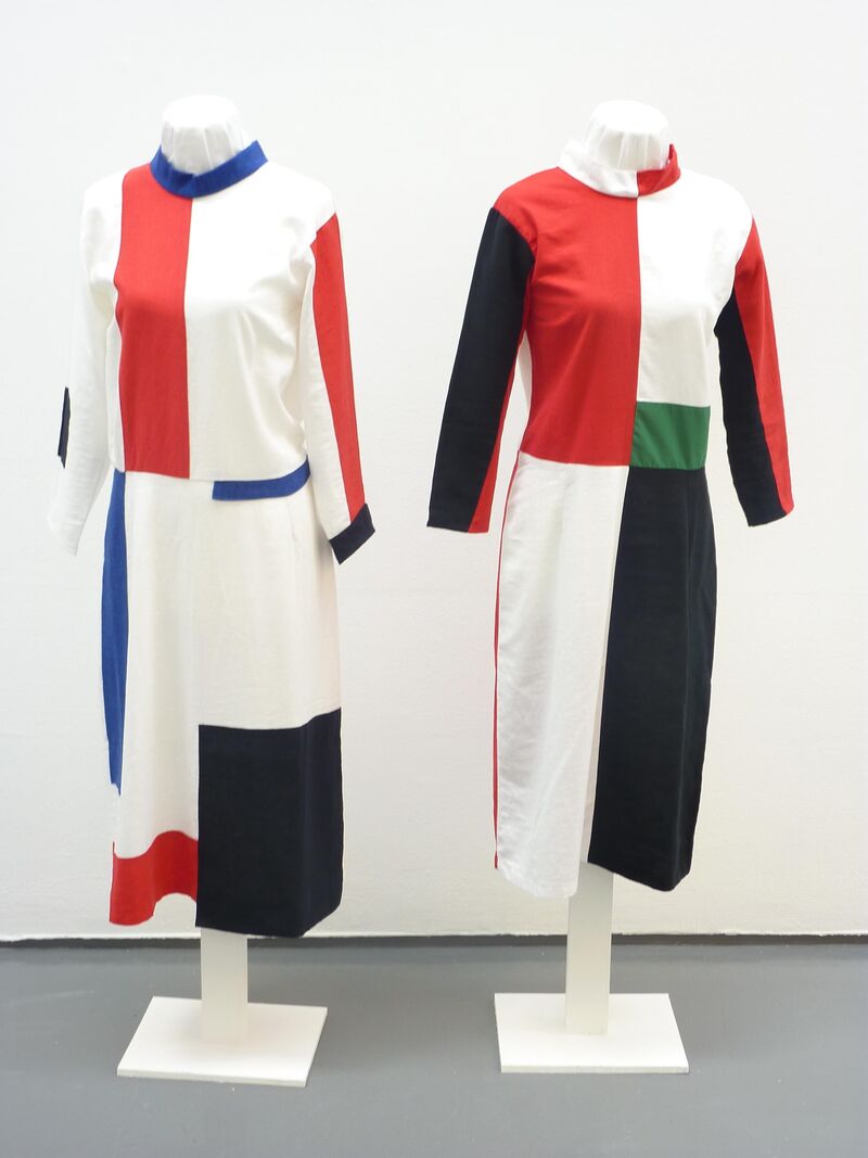 Two dresses, made out blue, red, black and white geometric patterns.