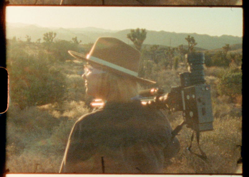A super 8 still of a man holding a super 8 film camera