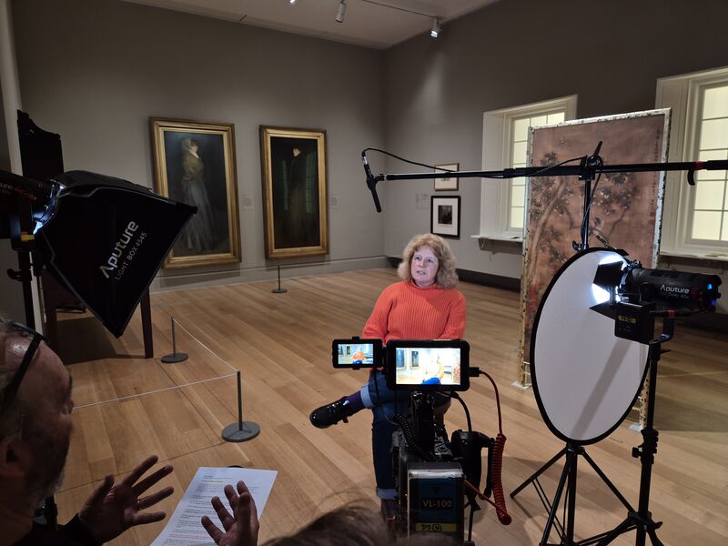 A woman being interviewed on camera in the exhibition