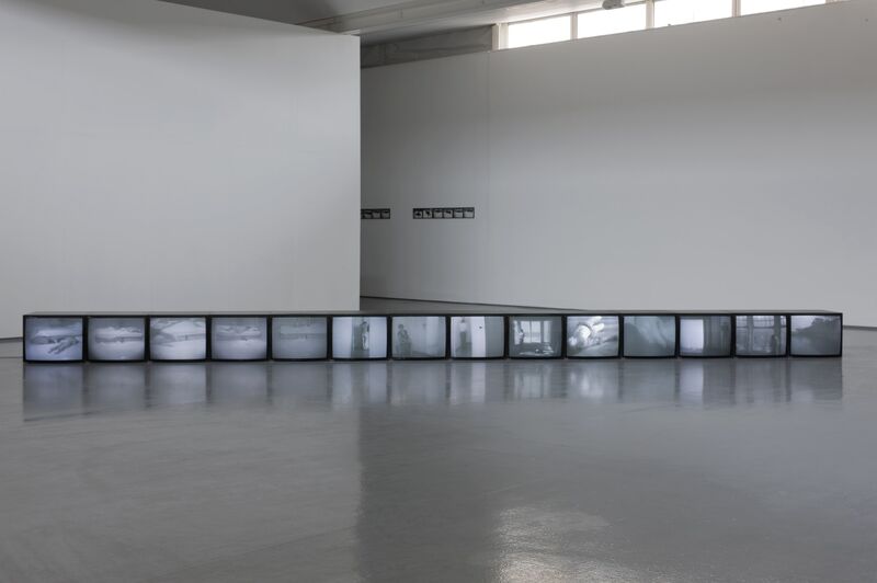 From the Ellipsis exhibition. A row of 14 televisions each display blurry black-and-white images.